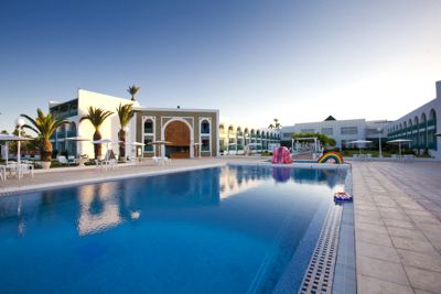 Swimming pool at dusk with the hotel behind at El Mouradi Cap Mahdia Swimming pool at dusk with the hotel behind at El Mouradi Cap Mahdia