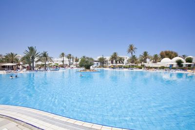 Large outdoor swimming pool with palm trees at El Mouradi Djerba Menzel Large outdoor swimming pool with palm trees at El Mouradi Djerba Menzel