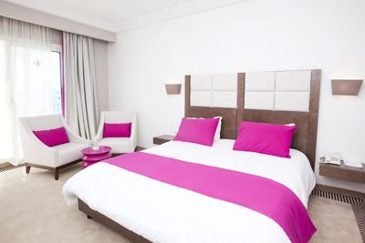 Double room with pink cushions and bed runner at El Mouradi Hammamet Double room with pink cushions and bed runner at El Mouradi Hammamet