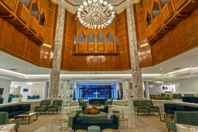 Hotel lobby with chandelier and lounge seating at El Mouradi Palace