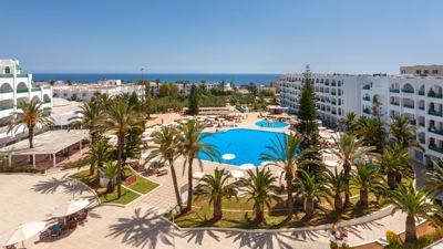 Swimming pool, palm trees and sea view from above at El Mouradi Palace