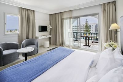 Superior room with balcony and blue bed runner at El Mouradi Palace