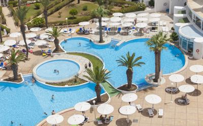 Swimming pools and sun umbrellas seen from above at El Mouradi Skanes